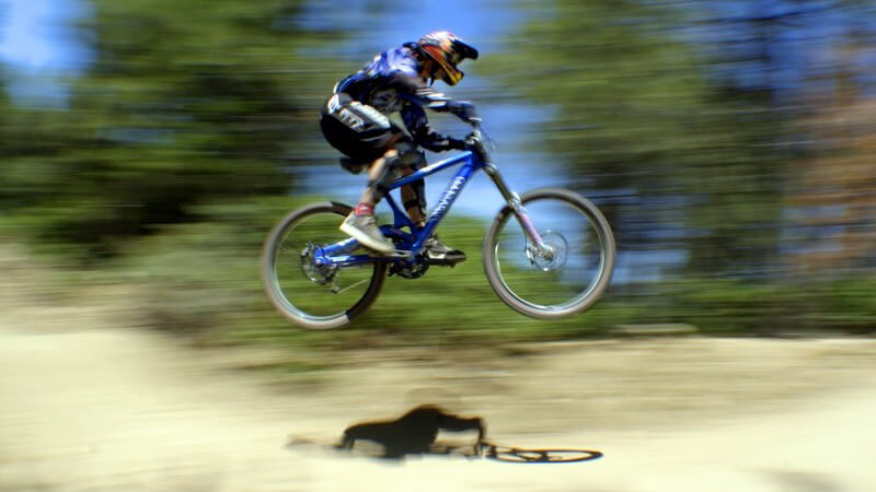 Mountainbike Fahrer beim Sprung in hoher Geschwindigkeit