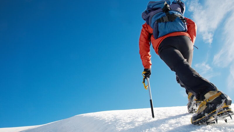 Schneewanderer mit Rucksack unter blauem Himmel