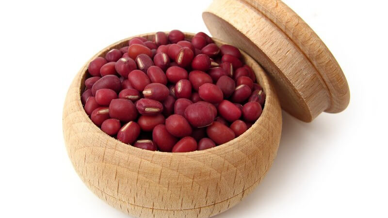 Azuki Bohnen in kleiner Holzdose, daneben Deckel