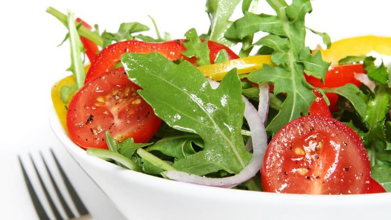 Frischer Salat mit Tomaten, Paprika, Zwiebeln in weißer Schale
