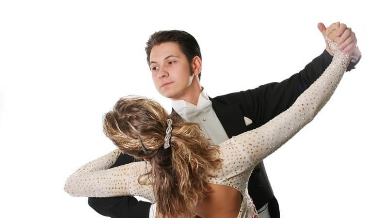 Mann und Frau im eleganten Outift beim Gesellschaftstanz auf weißem Hintergrund