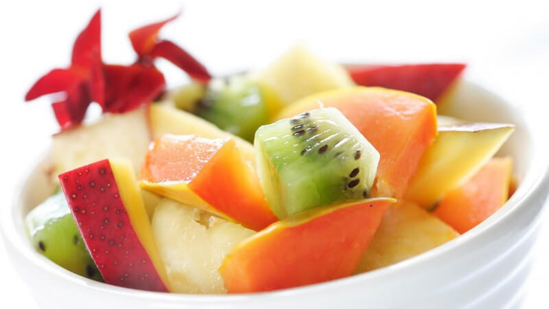 Südfrüchtesalat mit Kiwi und Mango in weiß-geriffelter Schale