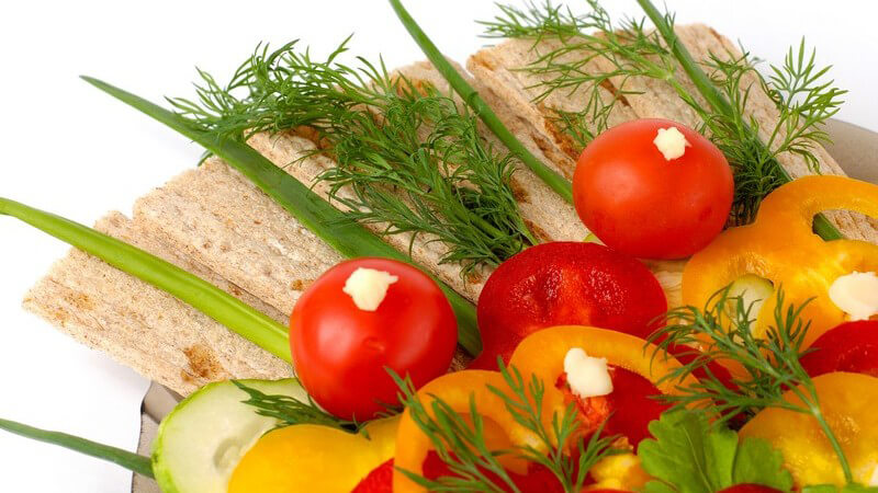Teller mit Auswahl an frischem Gemüse und Knäckebrot