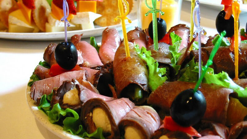 Essen - Kleine Fleischhäppchen mit Olive und Pieker auf Buffet-Teller