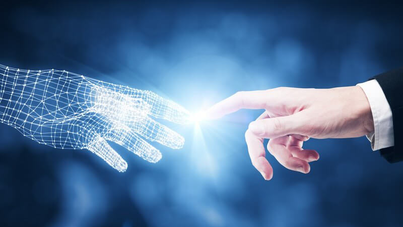 Zeigefinger einer Hand eines Geschäftsmannes berührt den Zeigefinger einer Computerhand