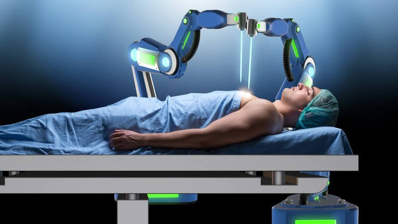 Mann liegt auf einer OP-Liege und wird von einem blauen Roboterarm operiert