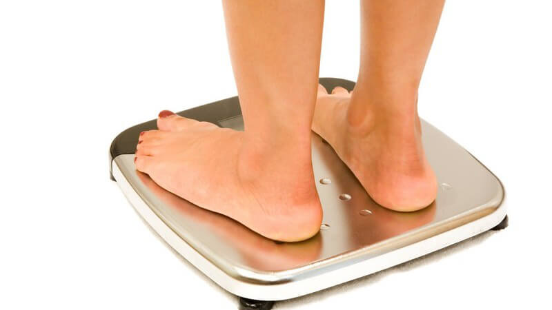 Frauenfüße auf einer Waage