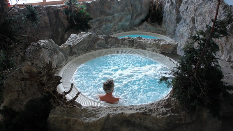 Ansicht von oben: Mann im Whirlpool im Wellness Schwimmbad