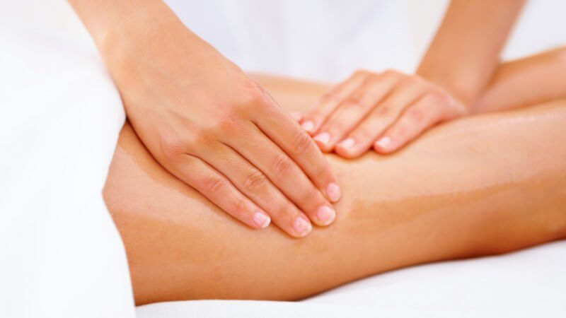 Frau bekommt Massage am Oberschenkel