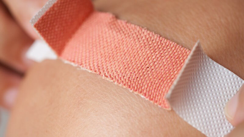 Pflaster wird auf Haut geklebt (Nahaufnahme)