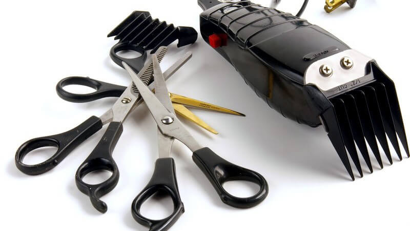 Scheren und Rasierer auf weißem Hintergrund