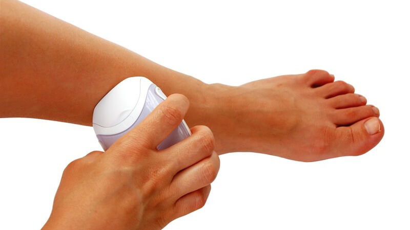 Frauenbein wird epiliert, weißer Hintergrund