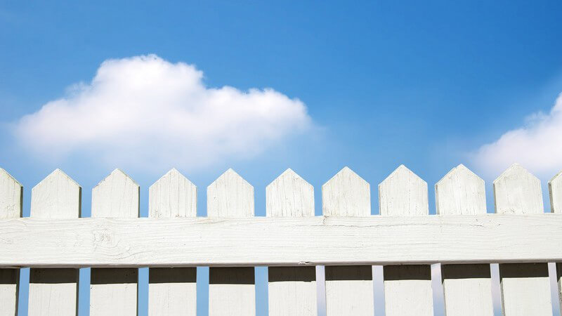 Weißer Lattenzaun unter blauem Himmel