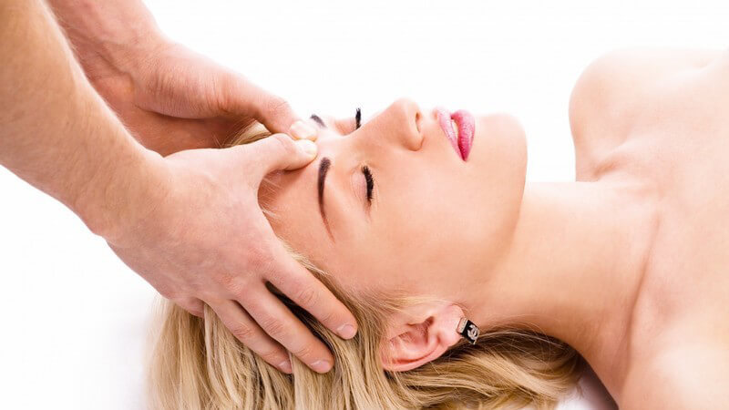 Gesichtsmassage bei einer blonden Frau zwischen den Augenlidern