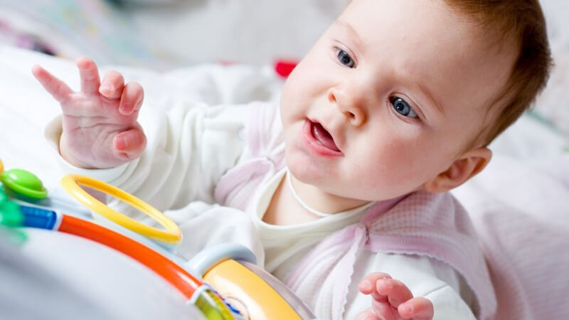 Baby spielt mit buntem Spielzeug