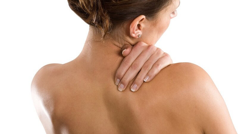 Rückansicht Frau hält sich am verspannten Nacken fest