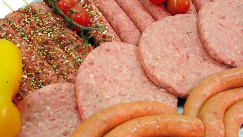 Fleisch und Wurst dekoriert mit Cherrytomaten und einer gelben Paprika