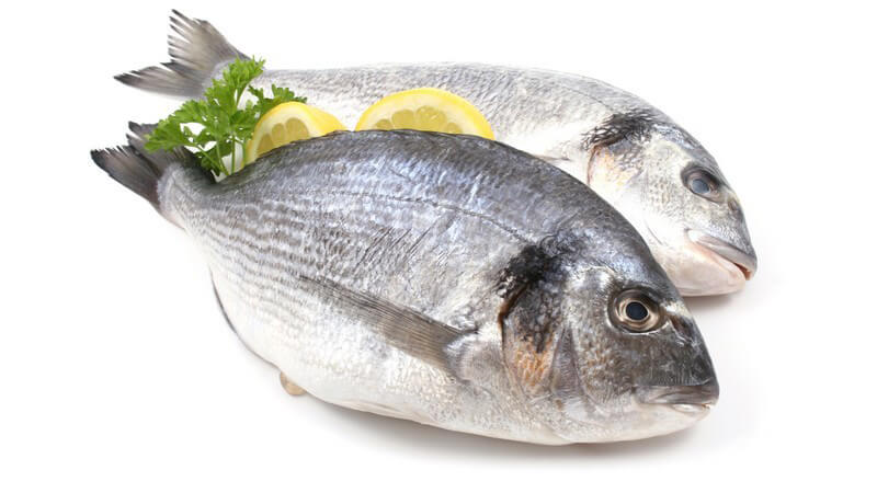 2 Doraden, dazwischen Petersilie und 2 Scheiben Zitrone