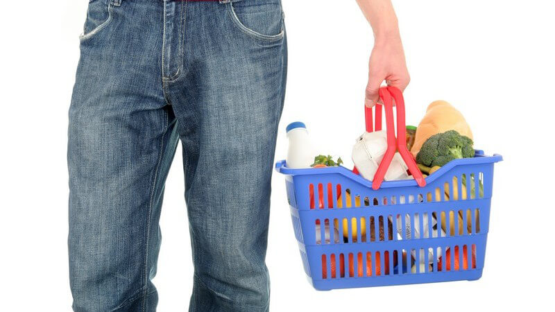 Unterer Körperausschnitt Mann mit Einkaufskorb auf weißem Hintergrund