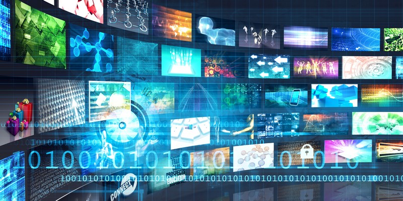 Die Zahlen Null und Eins vor einer Collage mit unzähligen Bildschirmen, auf denen verschiedene Videos laufen