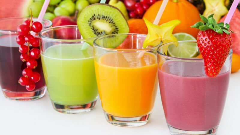 Vier verschiedene Smoothies aus Früchten (Johannisbeeren, Kiwis, Sternfrüchte und Erdbeeren)
