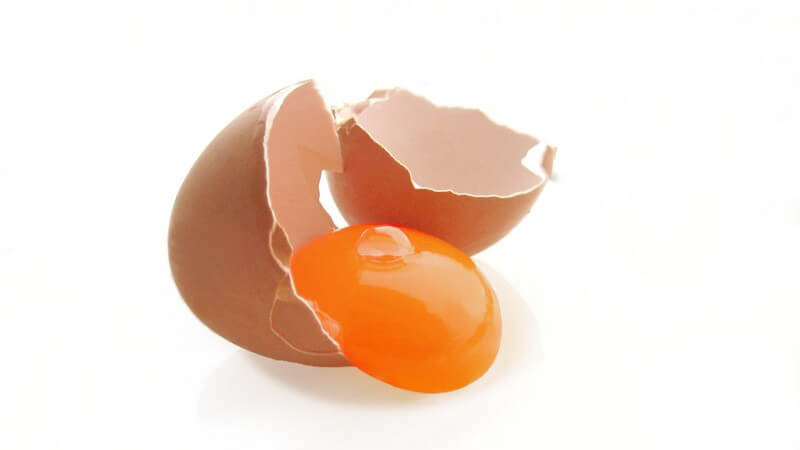 Aufgeschlagenes Ei, Eigelb am Rand der Eierschale