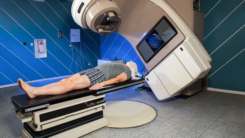 Mann liegt auf einer Liege und bekommt eine Bestrahlung (Strahlentherapie) zur Krebsbehandlung