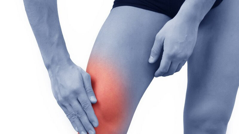 Männerbeine, Hand fasst an rot markiertes Knie, Knieschmerzen