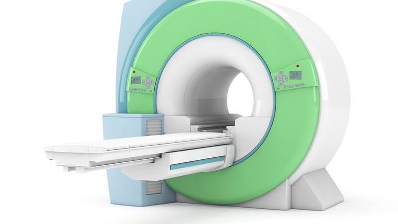 Grün-blauer Magnetresonanztomograph vor weißem Hintergrund