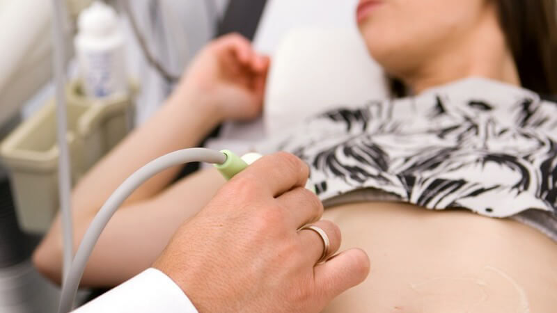 Junge Frau bei Ultraschalluntersuchung in Praxis