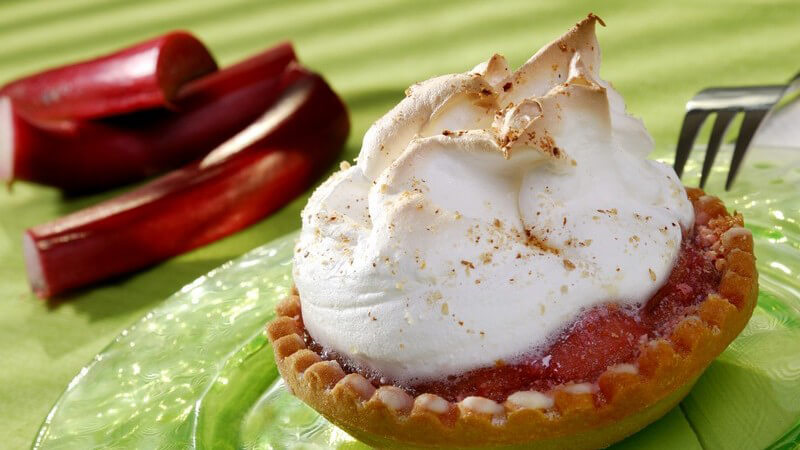 Kleiner Rhabarberkuchen mit Sahne auf Teller
