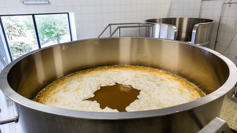 Blick in einen großen Gärtank in einer Brauerei, dichter Schaum auf der Würze