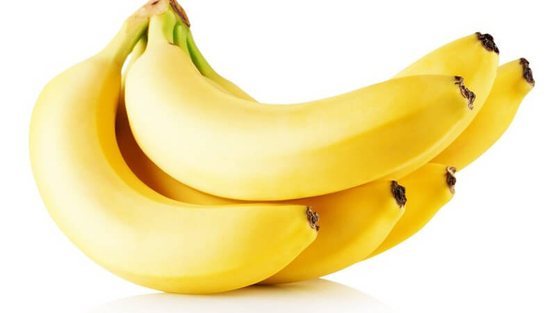 Sechs gelbe Bananen vor weißem Hintergrund