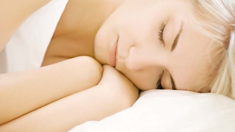 Nahaufnahme junge blonde Frau im Bett schläft