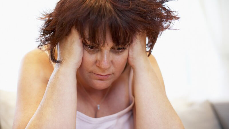 Unglückliche übergewichtige Frau fasst sich an den Kopf