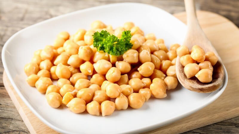 Teller mit Kichererbsen und Holzlöffel