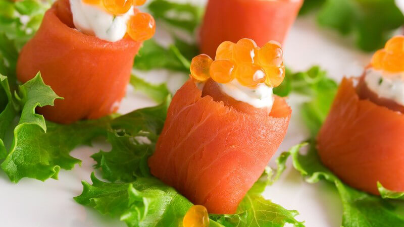 Nahaufnahme Häppchen aus Lachs und Kaviar auf Salatblatt