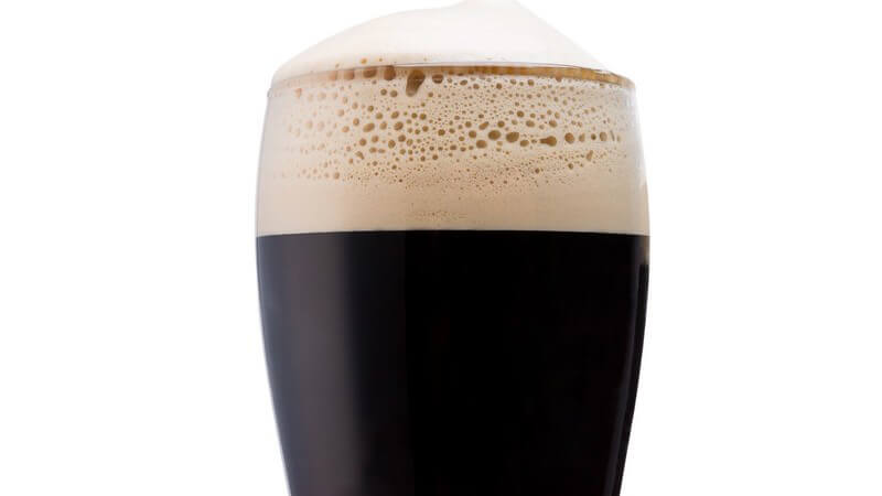 Volles Bierglas (Pint-Glas) mit irischem Stout vor weißem Hintergrund