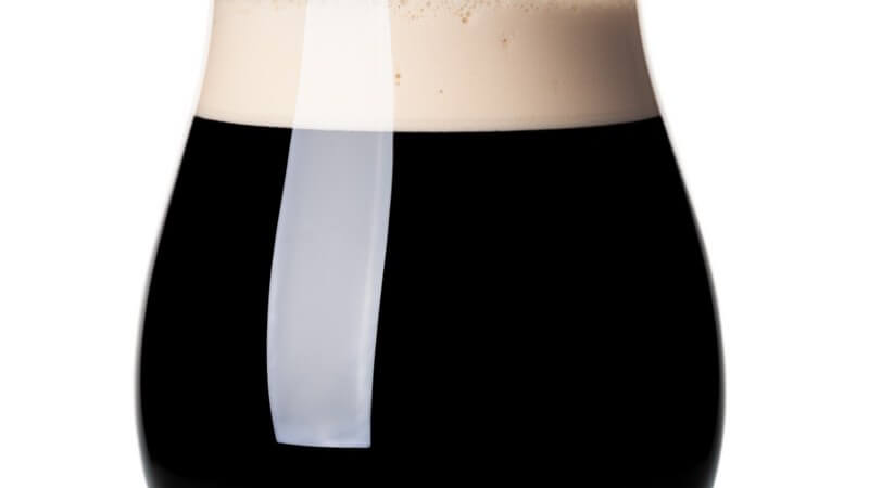 Volles Bierglas (Bierkugel) mit Schwarzbier oder Stout vor weißem Hintergrund