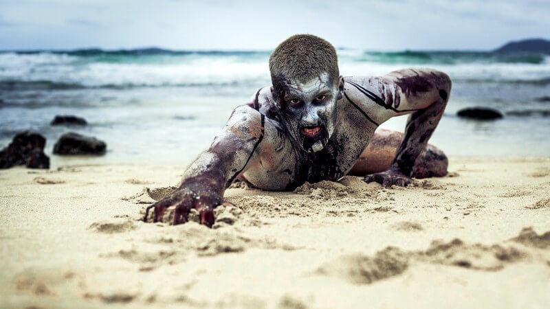 Zombie kriecht am Strand entlang
