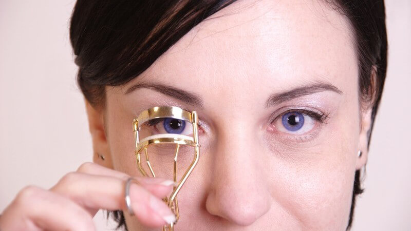 Junge Frau benutzt Wimpernzange