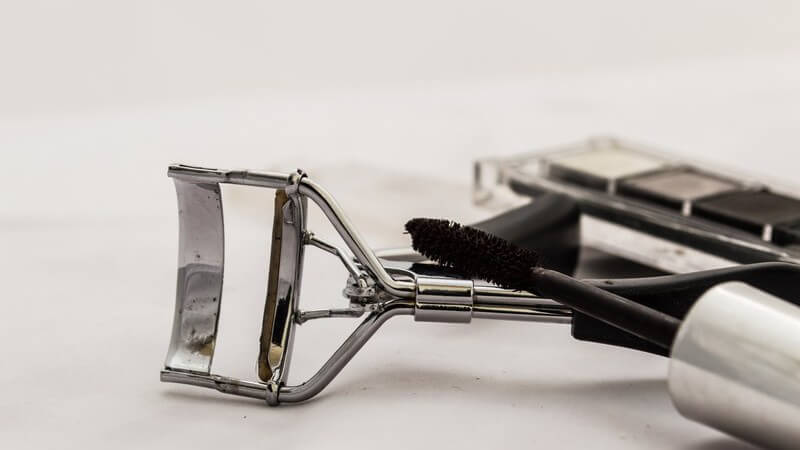 Silberne Wimpernzange und schwarzer Mascara