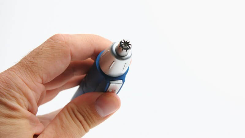 Hand hält Nasenhaartrimmer in Hand