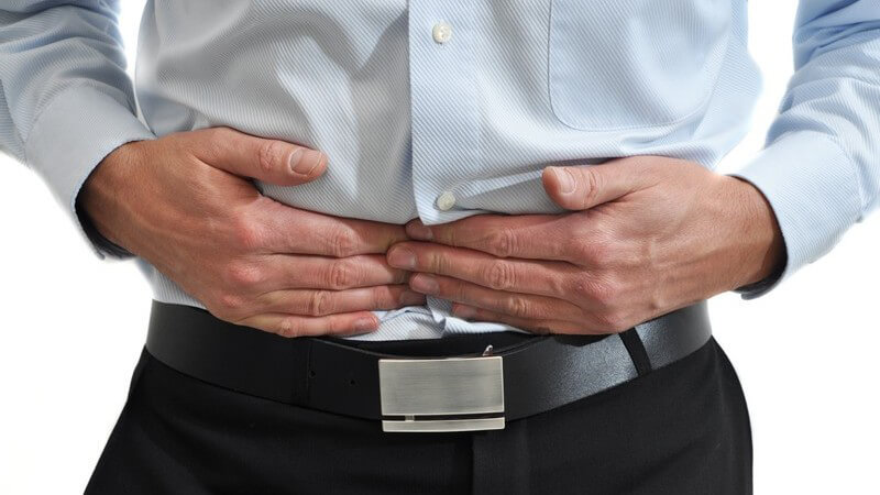 Ausschnitt Männerkörper, er drückt sich mit Händen an den Bauch, Bauchschmerzen
