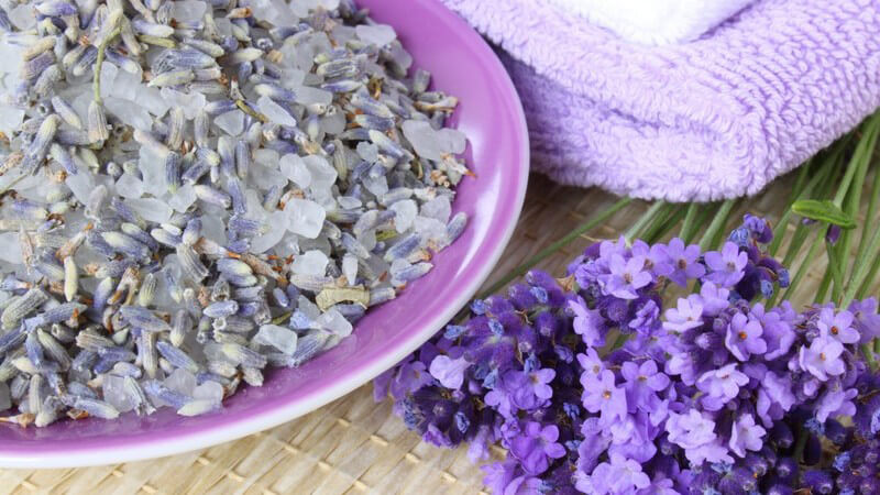 Lavendelblüten in und neben Schale, daneben Handtuch