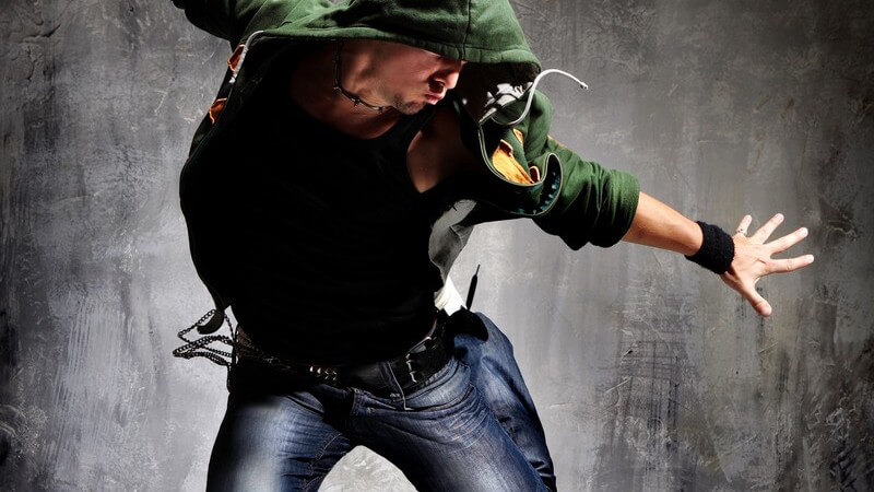 Junger sportlicher Typ mit Kapuze beim Tanzen, Schwebeaufnahme