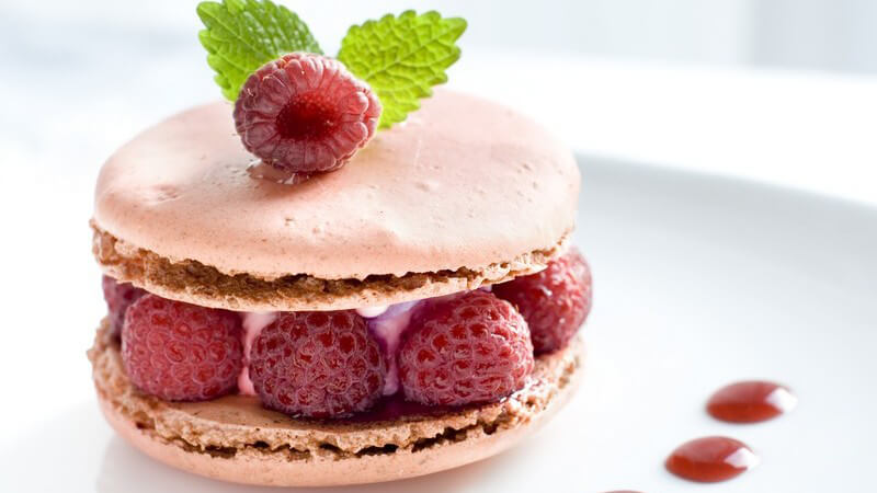 Kleiner Kuchen mit Himbeeren und Waffeln auf dekoriertem Teller