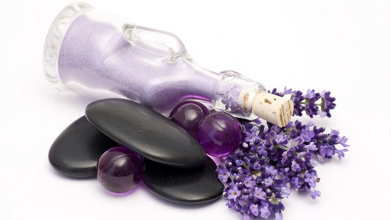 Lavendelblüten, Badesalz- und kugeln, Steine auf weißem Hintergrund