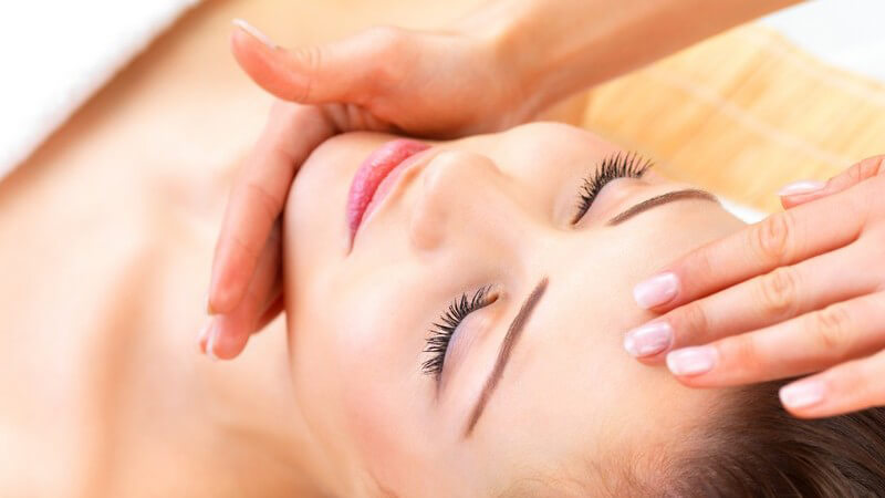 Frauengesicht wird von Frauenhänden massiert