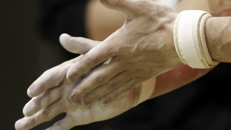 Hände eines Sportlers, die sich mit Magnesia einreiben